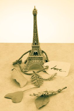 Eyfel Kulesi ve kahverengi bir arka plan üzerinde kuru yapraklar