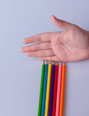 Beyaz arkaplana yerleştirilmiş el ele tutuşan kalemler