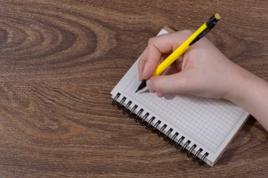 Kahverengi arka planda beyaz bir deftere el yazısı