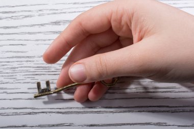 Ahşap doku üzerinde bir retro tasarımlı dekoratif anahtar tutan el