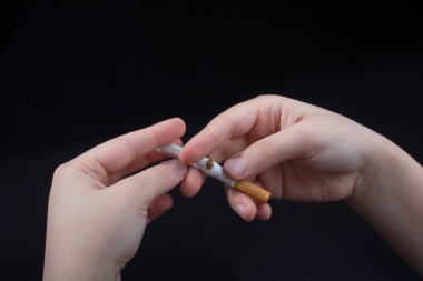 El siyah arka planda sigara kırıyor.