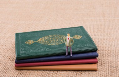 Adam heykelcik ayakta tuval üzerine küçük kitaplar