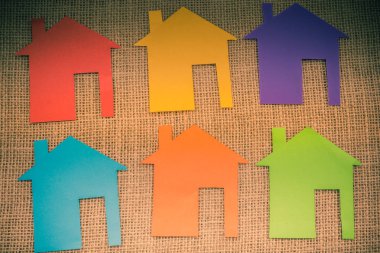 Tuvalin arka planında renkli kağıttan kesilmiş küçük bir ev şekli