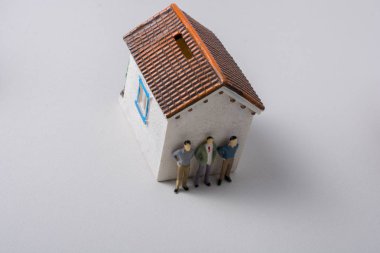 Evin önünde minyatür bir insan figürü.