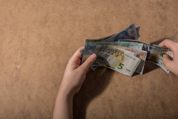 Hand holding American dollar  banknotes isolated on wooden background