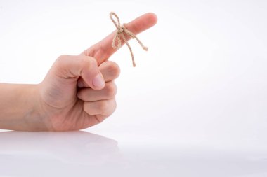 Beyaz arka plandaki bir kurdele gibi iplikle bağlanmış bir el.