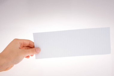 Beyaz arka planda bir kağıt parçasını tutan el.