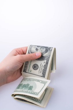 İnsan eli, Amerikan doları banknotunu beyaza izole edilmiş olarak tutuyor.