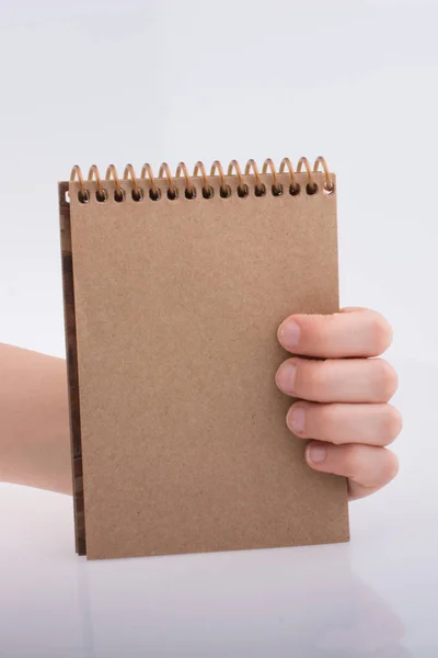 Hand Houden Van Een Bruine Spiraal Notebook Een Witte Achtergrond — Stockfoto