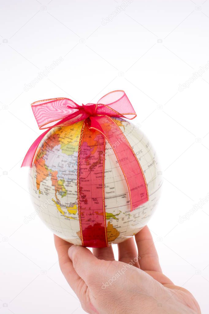 Globe tied with red ribbon on a white background