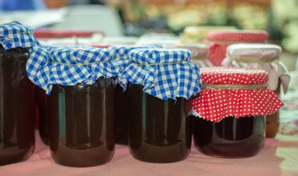 Jam in jars covered with fabric in the view