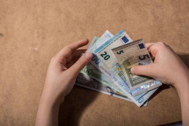El ele tutuşan Amerikan doları banknotları ahşap arka planda izole edilmiş.