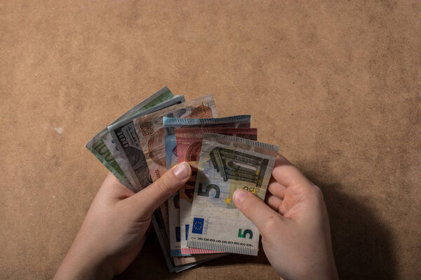 Hand holding American dollar  banknotes isolated on wooden background