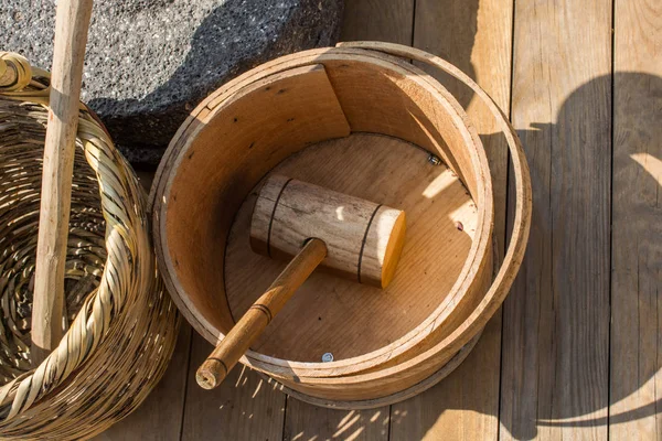 Wooden mallet in a wooden bucket on display