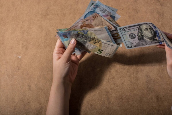 Hand holding American dollar  banknotes isolated on wooden background