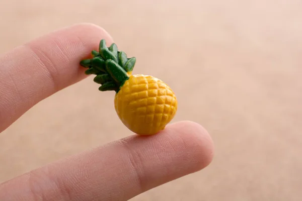 Hand Hält Eine Winzige Ananas Miniatur Auf Einem Ausgestellten Hintergrund — Stockfoto