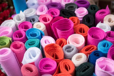 Manzarada düzinelerce renkli kumaş yuvarlanıyor.