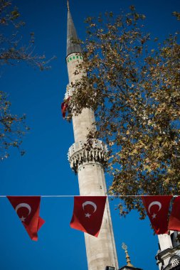 Bir minare bir iple bir direğe Türk ulusal bayrak dayan