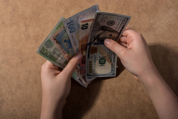 Hand holding American dollar  banknotes isolated on wooden background