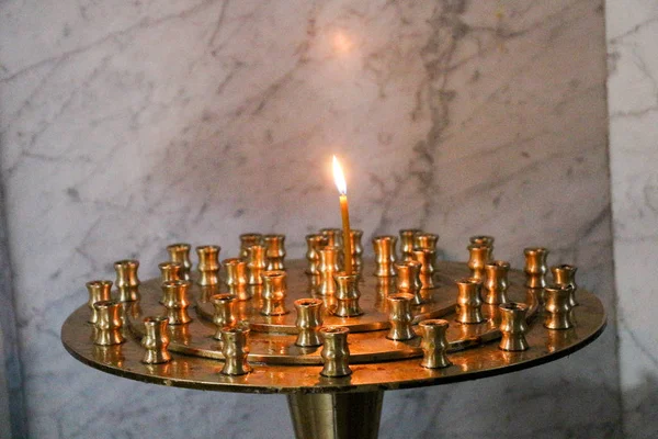 Candle burning over dark background in a church