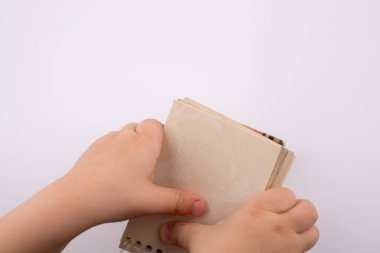 Beyaz bir arka plan üzerinde bir sarmal boş defter tutan bebek