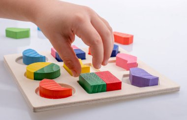 Elinde mantık bulmacasının renkli ahşap parçaları