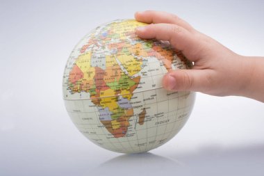 Beyaz arka planda bir küreyi tutan çocuk