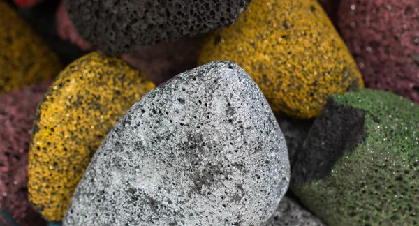 Many multicolored porous pumice stones in view