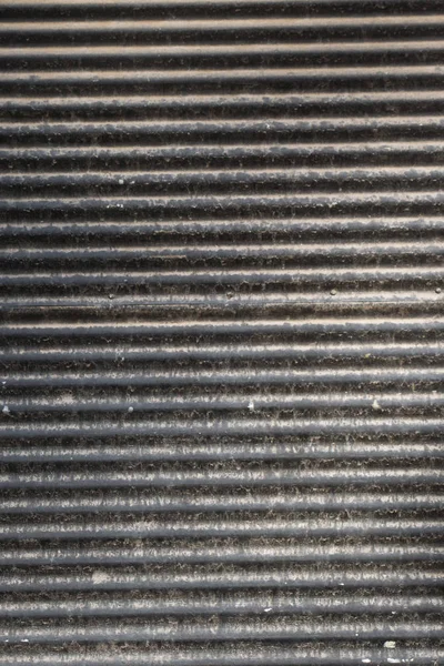 Straight lines on a shop front shutter as a metal background