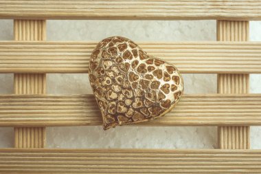 Altın rengi kalp şekilli. Dekoratif nesne görünüyor.