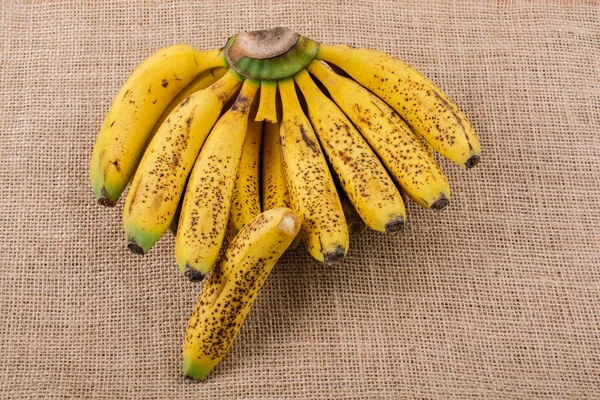 Stelletje Gele Sproeten Bananen Een Canvas Textuur — Stockfoto