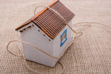 Kahverengi bir arka plan üzerinde bir model ev iplik sarılı