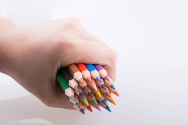 Beyaz arkaplanda el ele tutuşan renkli kalemler