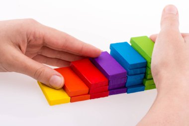 Beyaz arkaplanda renkli domino taşıyla el oyunu