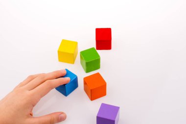 Beyaz arka planda renkli küplerle el oynamak