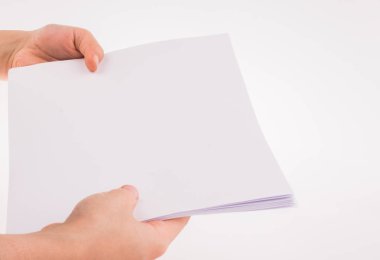 Beyaz bir arka plan üzerinde beyaz bir boş sayfa tutan el