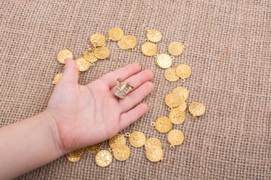 Küçük model tacın etrafında sahte altın paralar var.