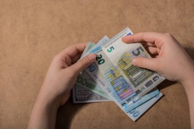 El ele tutuşan Amerikan doları banknotları ahşap arka planda izole edilmiş.