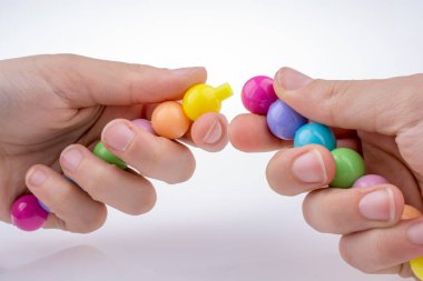 Beyaz arkaplanda yüz ifadesi olan renk boncukları.