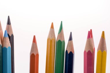 Beyaz arkaplanda çeşitli renklerde renkli kalemler