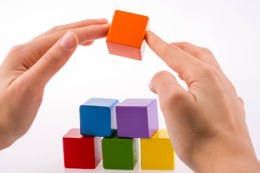 Beyaz arka planda renkli küplerle el oynamak