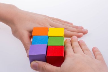 Beyaz arka planda renkli küplerle el oynamak