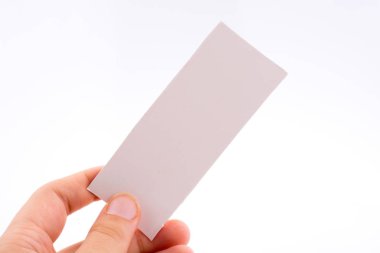 Beyaz arka planda bir not kağıdı tutuyor.