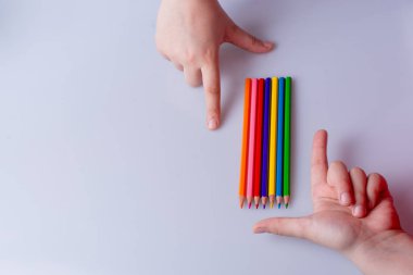 Beyaz arkaplana yerleştirilmiş el ele tutuşan kalemler