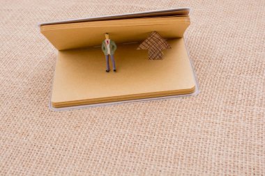 Heykelcik ve tuval üzerine bir defter kağıt ok