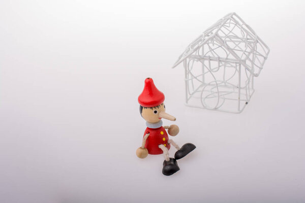 Pinocchio sitting beside model house
