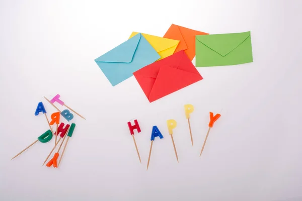 colored envelopes and Color candles on sticks write happy