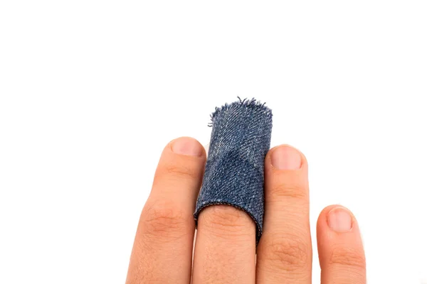 Hand holding a denim fabric piece on white background