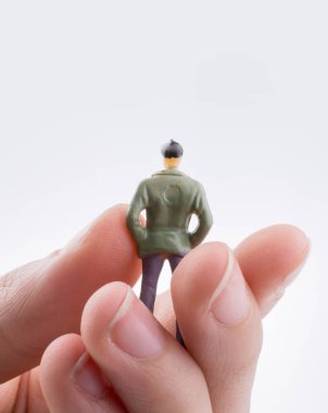 Beyaz arka planda bir insan figürü tutuyor.