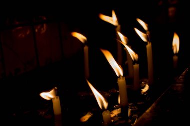 Karanlıkta mum ışığında yanan mumlar.